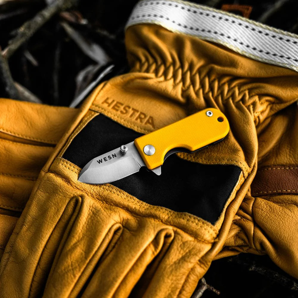 WESN Microblade fickkniv i gult i handen, lifestylebild