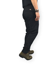 Dickies 247 Slim Work Pant arbetsbyxor i svart, från sidan med Dickies-etikett, på modell