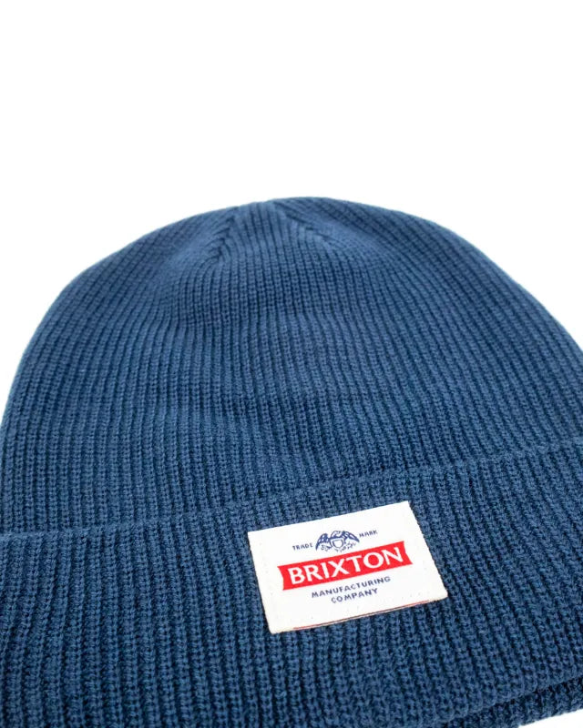 Brixton Trademark Beanie i marinblått, detaljbild på ribbstickning och etikett