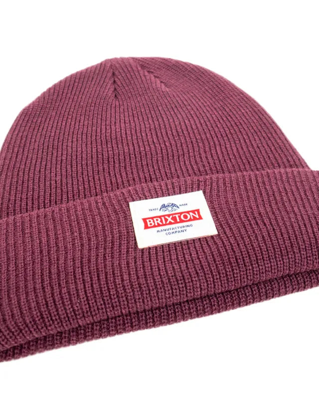 Brixton Trademark Beanie i vinrött, detaljbild på ribbstickning och etikett