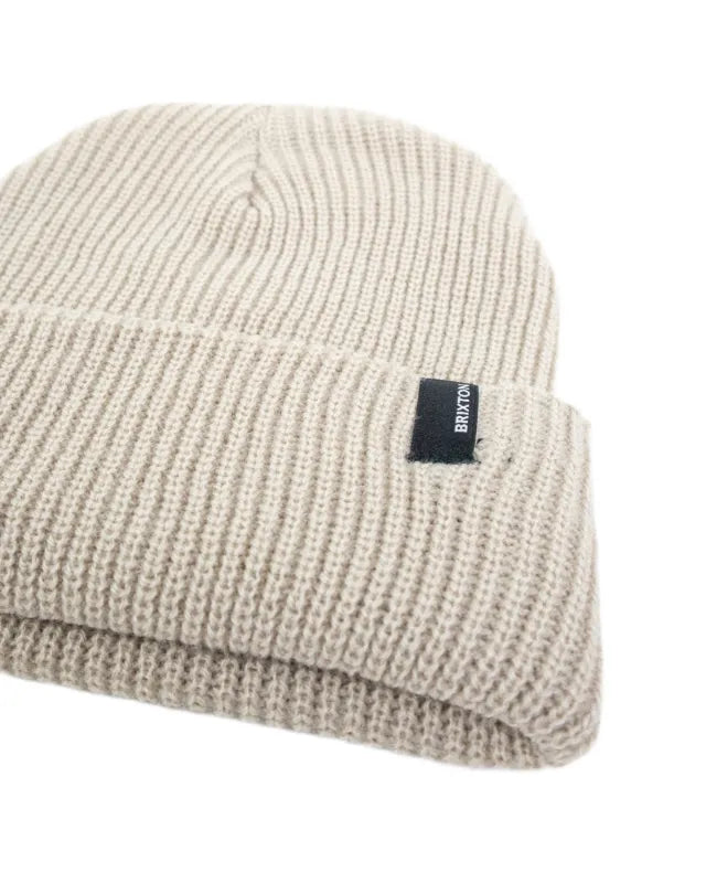 Brixton Heist Beanie i beige, detaljbild på ribbstickning och vävd etikett