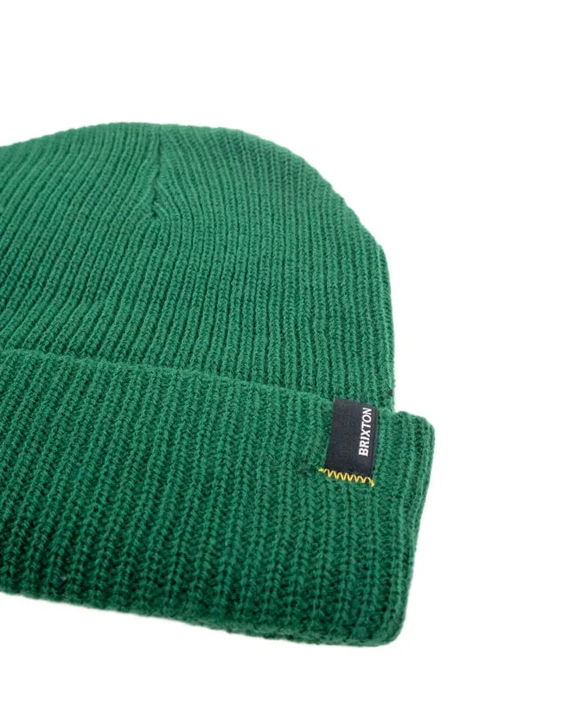 Brixton Heist Beanie i mörkgrönt, detaljbild på ribbstickning och vävd etikett