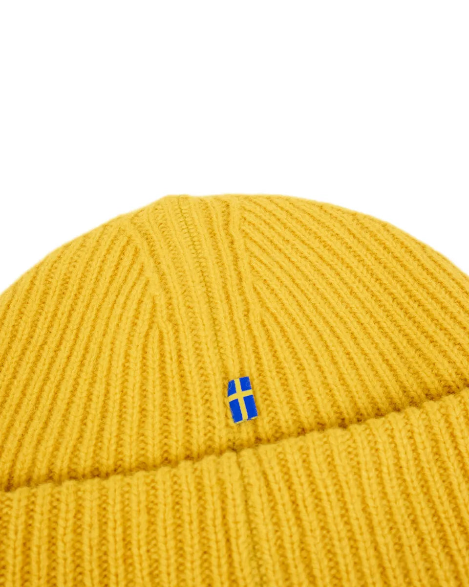 Fjällräven 1960 Logo Hat i senapsgul lammull, närbild på flaggan
