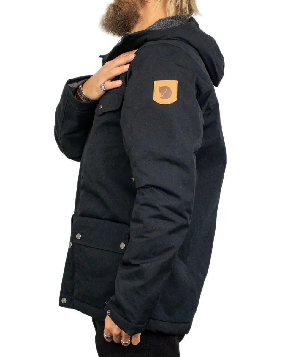 Fjällräven Greenland Winter Jacket i svart, från sidan med rävlogga på ärmen